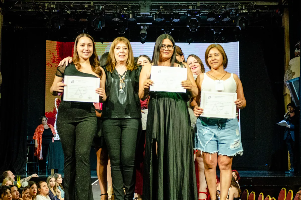 Alumnas con su certificado en el escenario del desfile de fin de año.