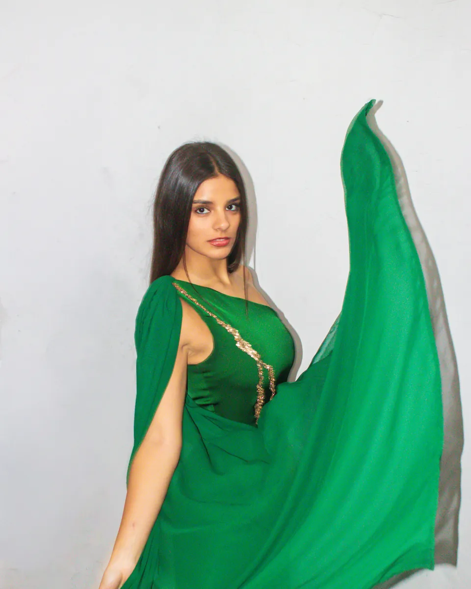 Vestido verde con capa diseñado por una alumna de la escuela.