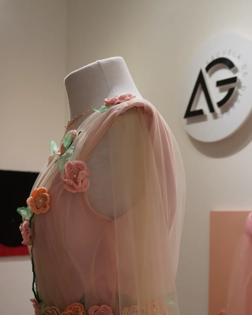 Vestido de tul con flores aplicadas, de una alumna de la escuela, en exhibición.