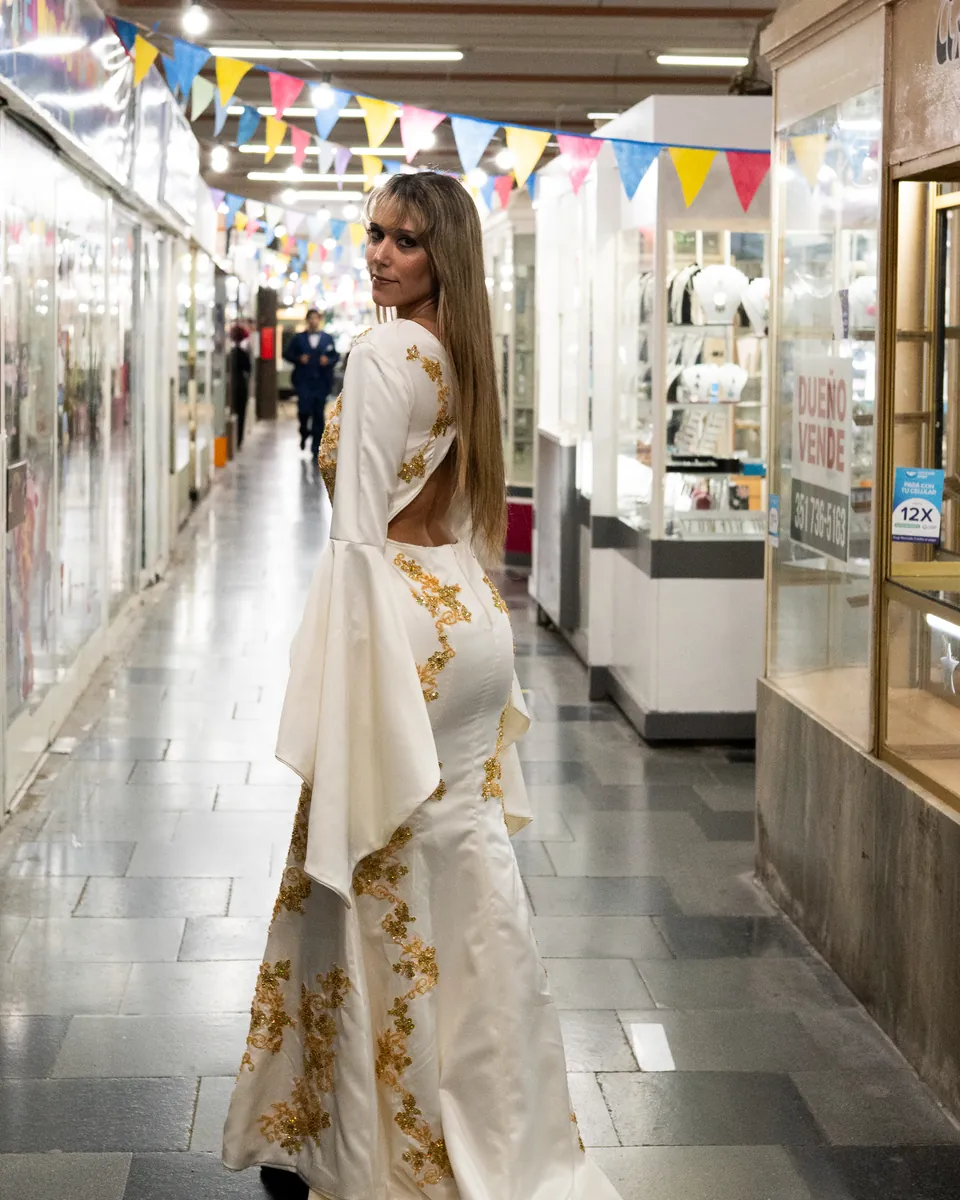 Vestido largo blanco y dorado diseñado por una alumna de la escuela.
