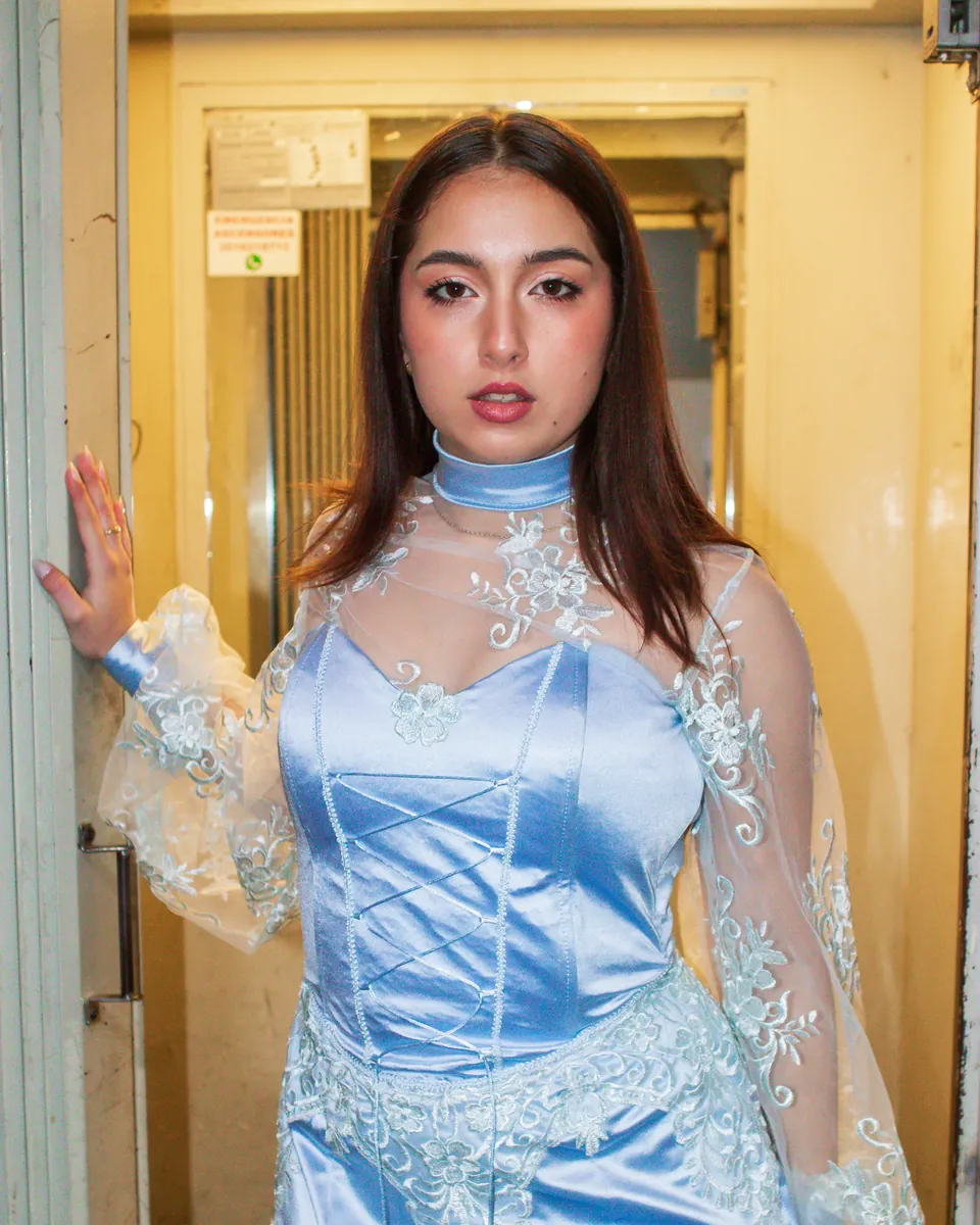 Vestido celeste con mangas de tul diseñado por una alumna de la escuela.